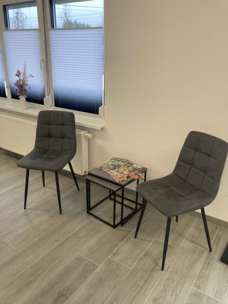 Wartebereich mit Sesseln und kleinem Beistelltisch mit Zeitschriften